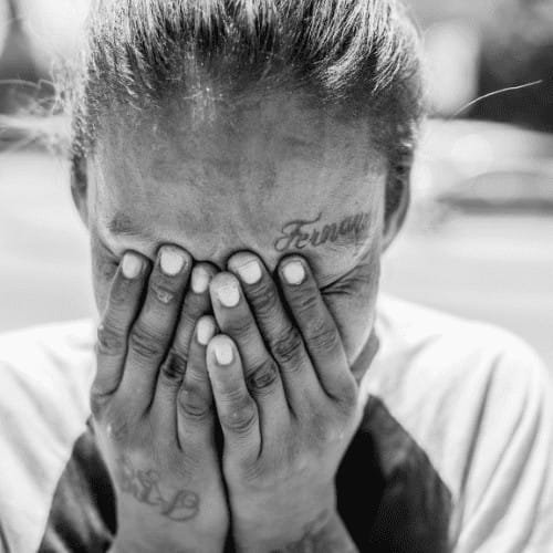 Mujer tapandose la cara representando el dolor por sufrir una adicción o dependencia a la marihuana.